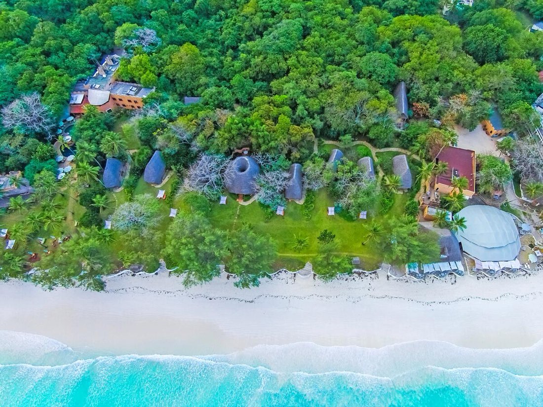 Holiday in Kenya — white-sand beach and turquoise water at Diani Beach, from above.