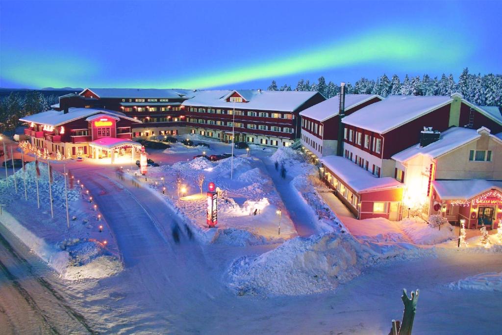 Holiday in Lapland — snowy hotel in Levi under the northern lights.
