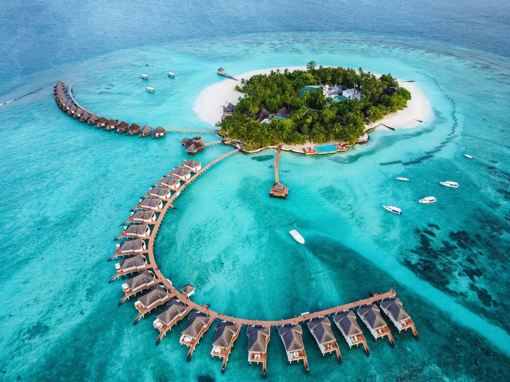 Exotic holiday in the Maldives — turquoise lagoon and white beach on an Indian Ocean atoll.