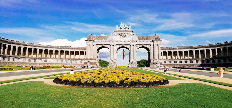 Parter cu flori galbene și peluze în fața arcului Cinquantenaire, plimbare city break Bruxelles - rezervare hoteluri