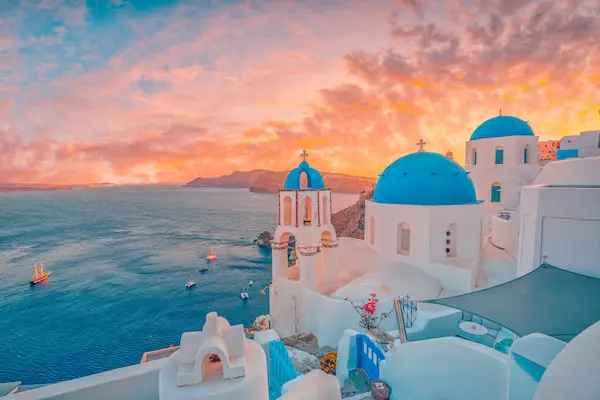 Cupole albastre si clopotnite din Oia iluminate de apus, Santorini, Grecia